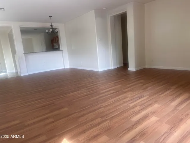 a view of a room with wooden floor and a ceiling fan