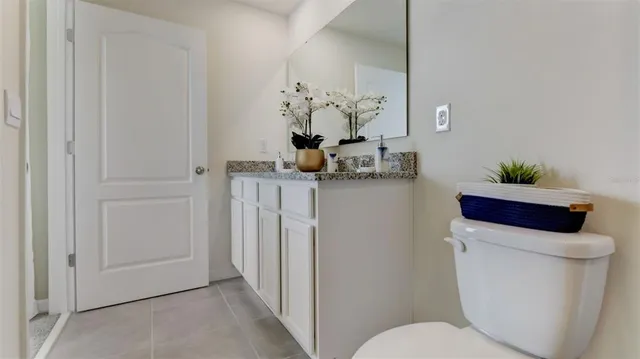 a bathroom with a granite countertop sink a toilet and a bathtub