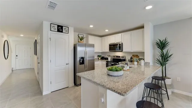 a kitchen with stainless steel appliances granite countertop a refrigerator and a stove top oven