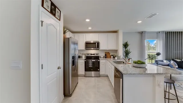 a kitchen with a sink a counter and chairs