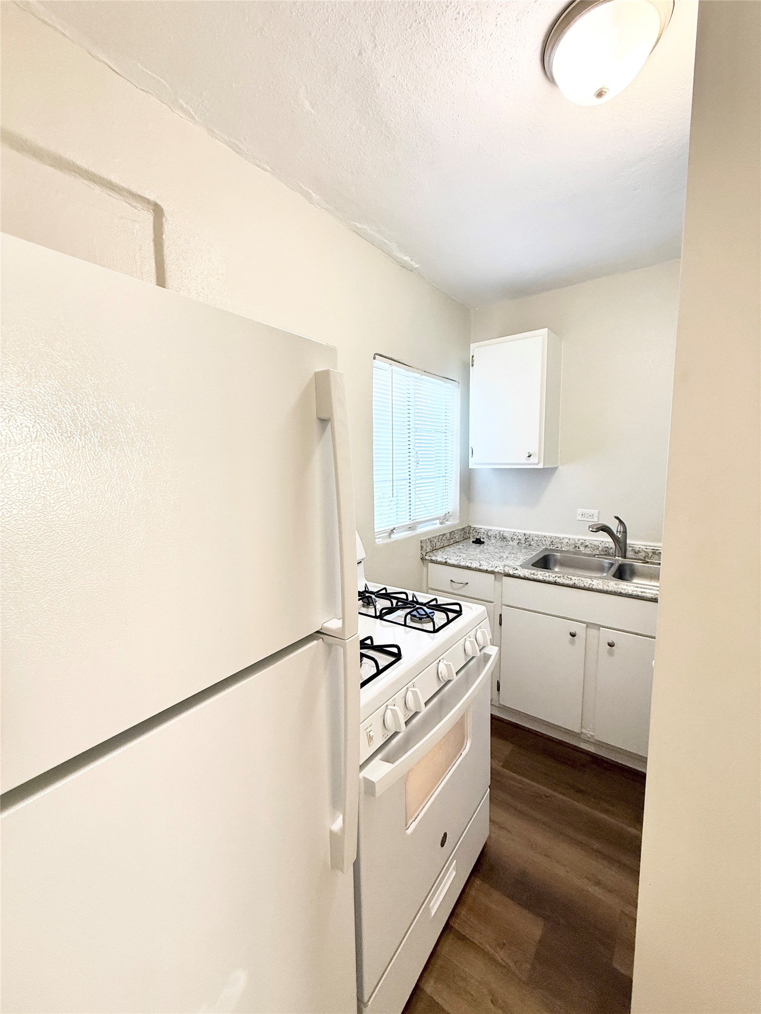 2717 Hadley Street, Unit 16 Houston, TX 77004 - Photo 7 of 27 a kitchen with granite countertop cabinets and white appliances