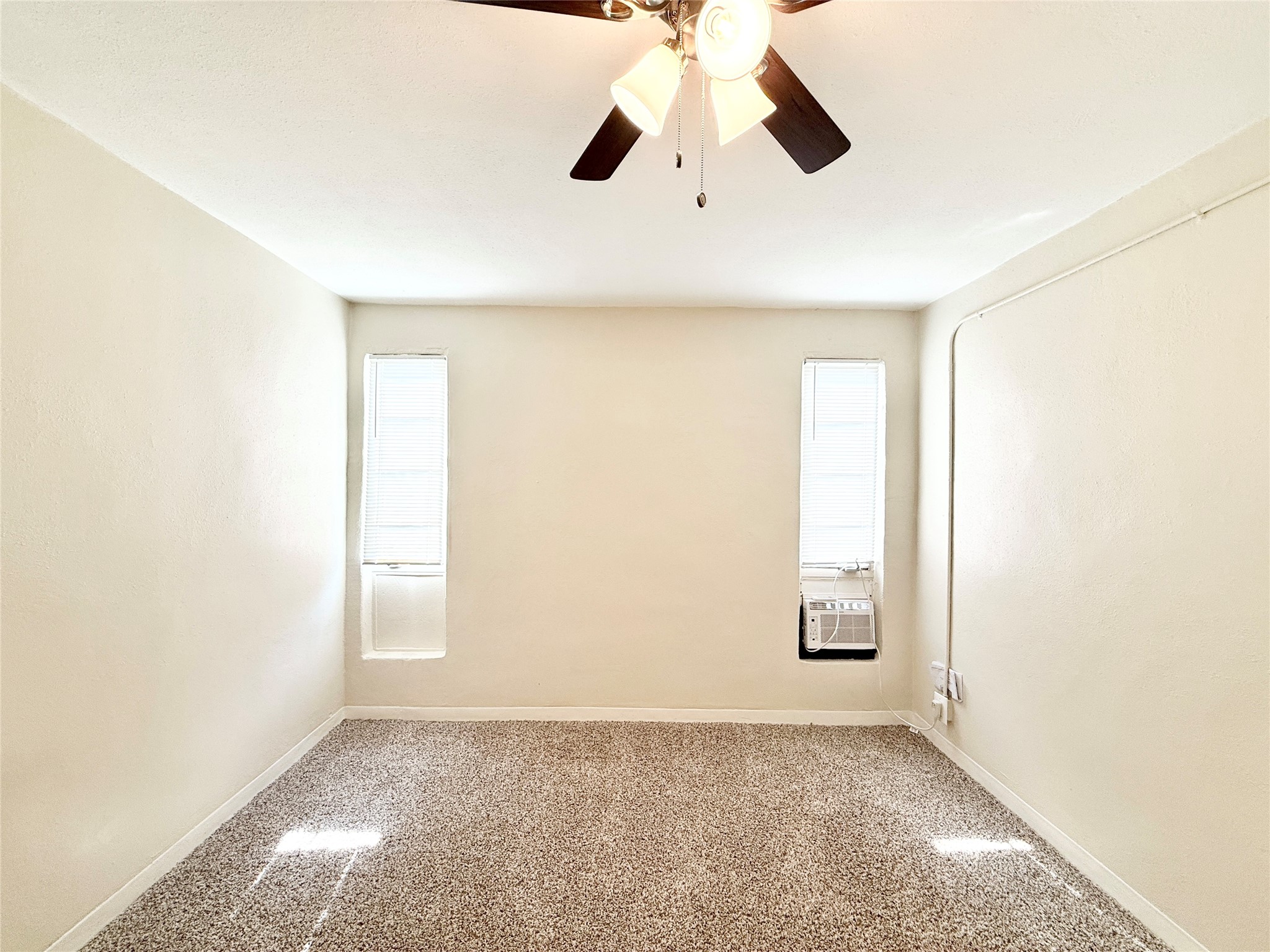 2717 Hadley Street, Unit 16 Houston, TX 77004 - Photo 10 of 27 an empty room with windows and fan