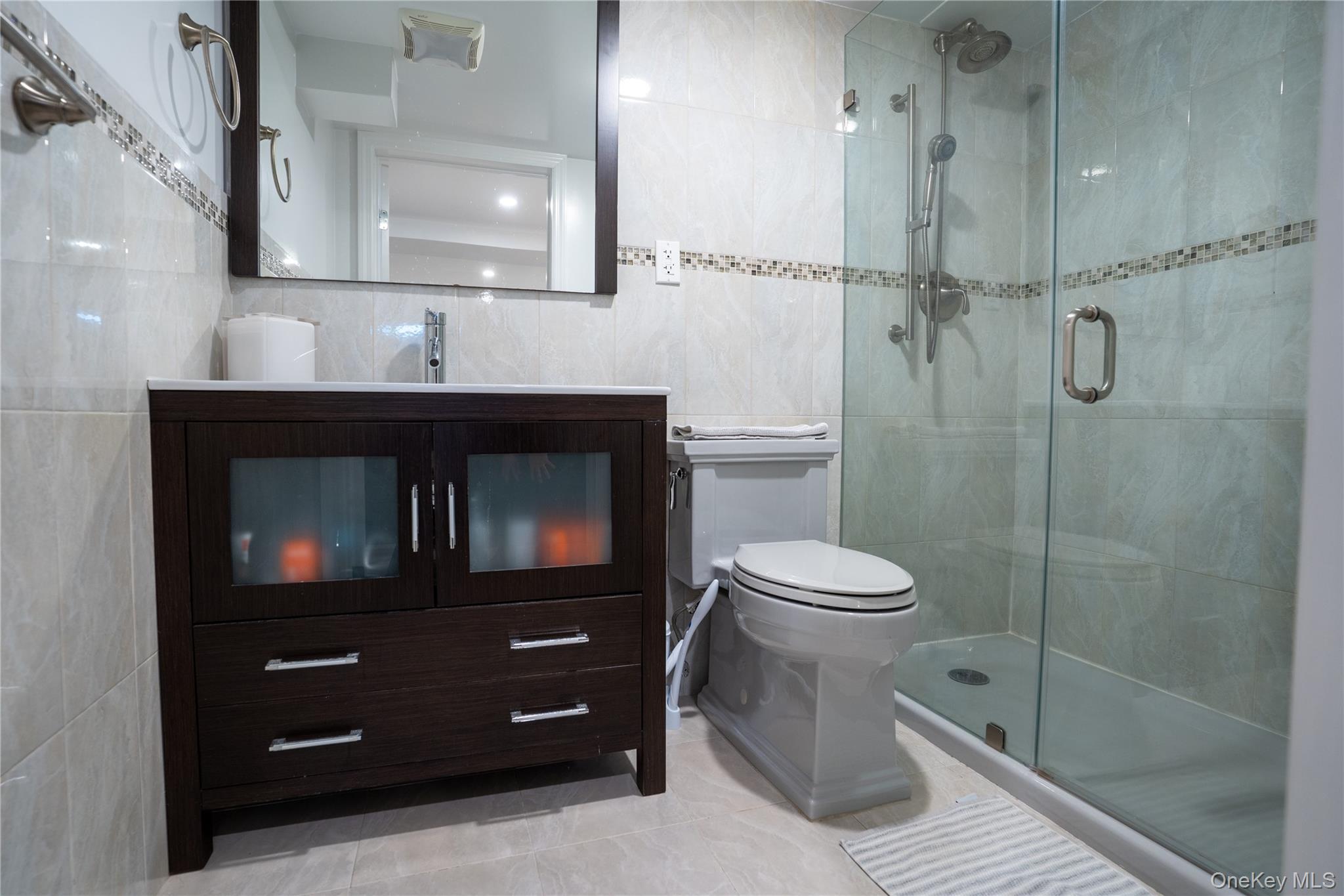 222-36 41st Road Queens, NY 11361 - Photo 18 of 21 a bathroom with a toilet a sink and mirror