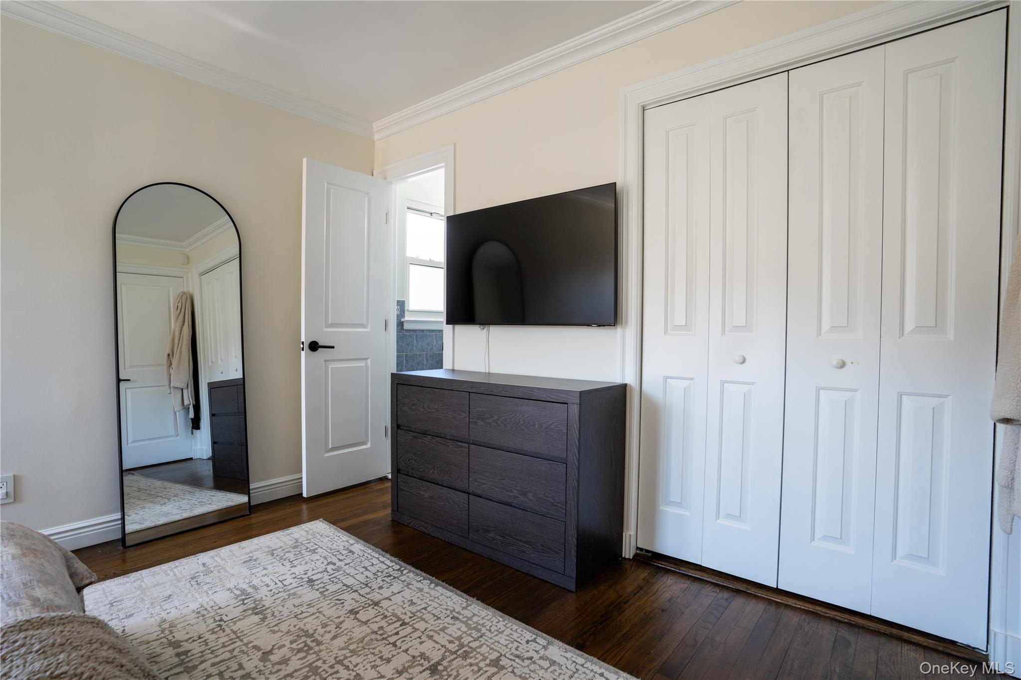 222-36 41st Road Queens, NY 11361 - Photo 9 of 21 a room with a mirror and a dresser