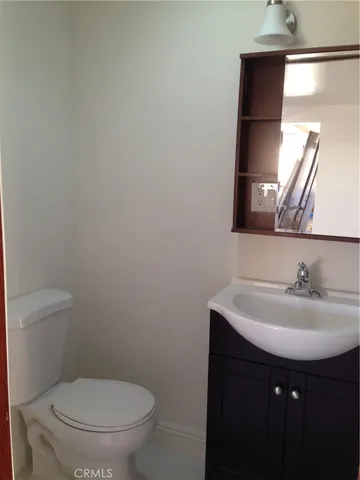 a bathroom with a sink toilet and mirror