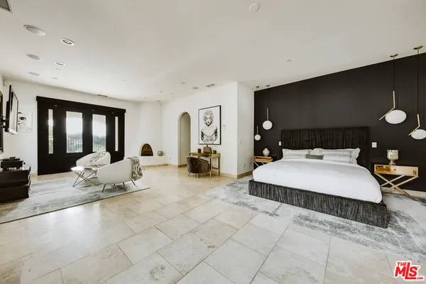 a spacious bedroom with a bed and glass door