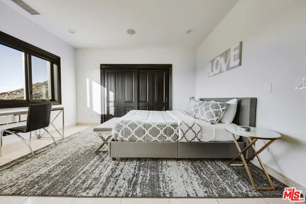 a bed sitting in a bedroom next to a window