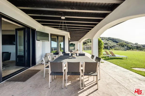 a view of a patio with a table chairs and a backyard
