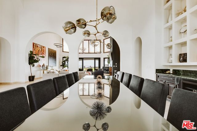 a view of a dining room with furniture a chandelier and wooden floor
