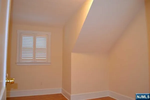 a view of a small space with wooden floor and a window