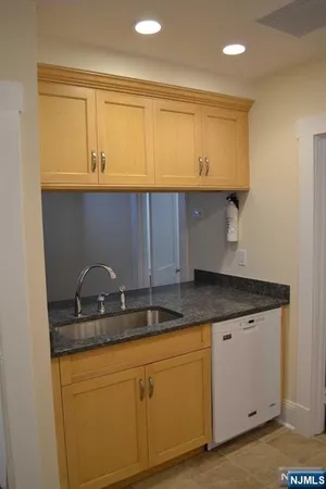 a kitchen with granite countertop a sink and cabinets