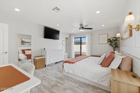 a bedroom with furniture and a flat screen tv