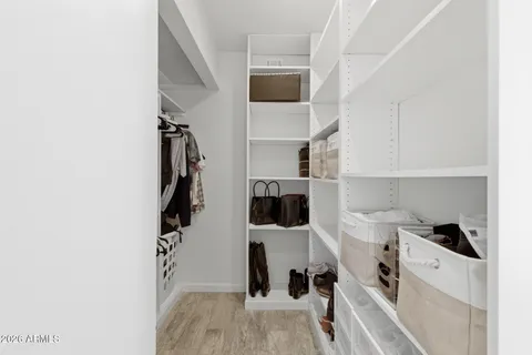 a view of walk in closet with clothes and shoes