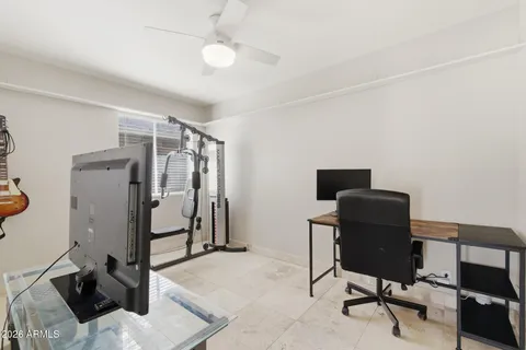 a view of a workspace with furniture and a ceiling fan