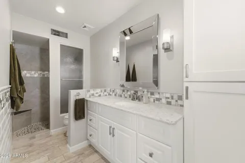 a bathroom with a double vanity sink mirror and shower