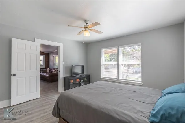 a spacious bedroom with a large bed and a chandelier