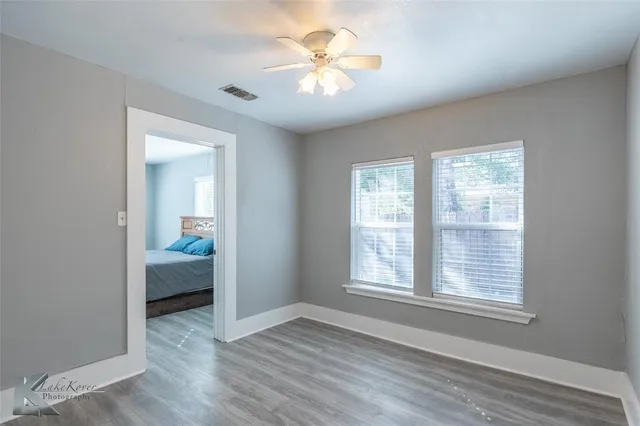 a view of a room with a ceiling fan and a window