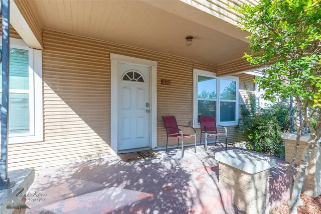 a view of a house with backyard and chairs