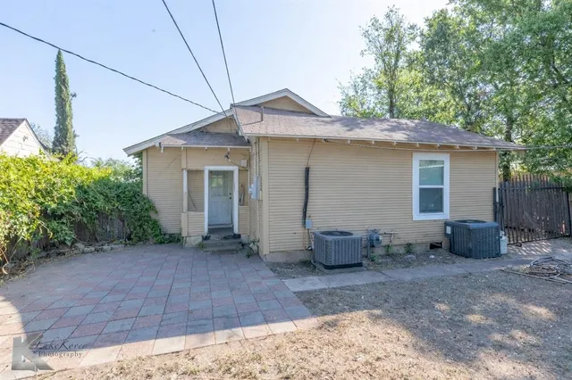 a backyard of a house with outdoor seating and barbeque oven