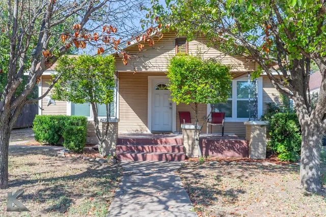 a view of a house with a tree in front