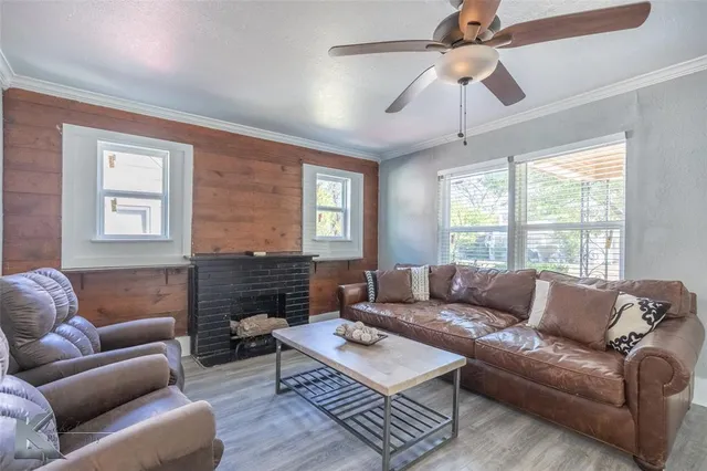 a living room with furniture a fireplace and a window