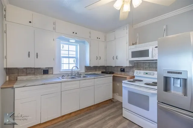 a kitchen with granite countertop a sink stainless steel appliances and cabinets
