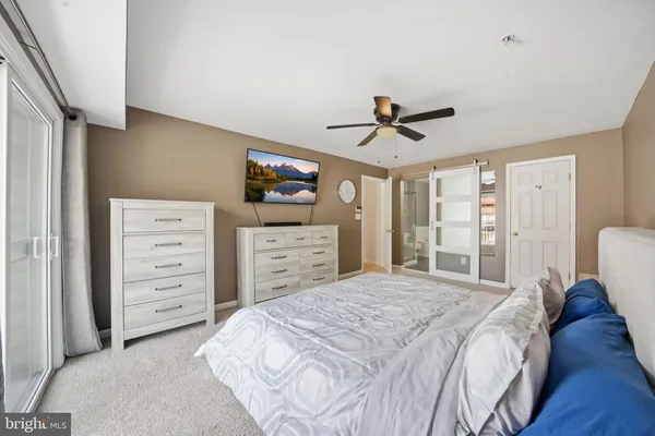 a bedroom with a bed a chandelier and a dresser