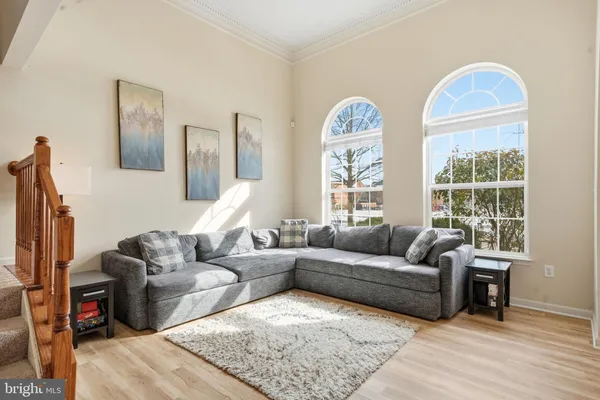 a living room with furniture wooden floor and a large window
