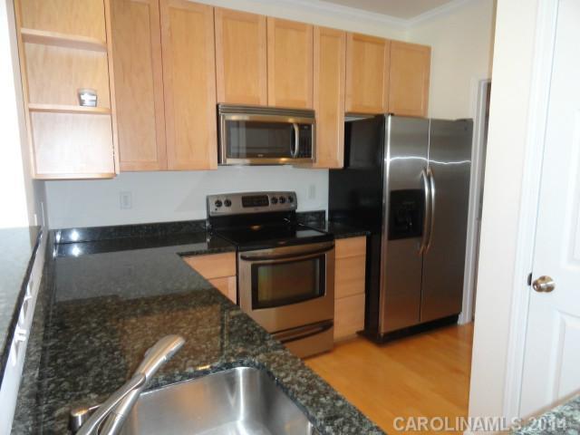 608 Raphael Place, Unit 608 Charlotte, NC 28205 - Photo 5 of 14 a kitchen with stainless steel appliances granite countertop a refrigerator a stove and a sink with wooden floor