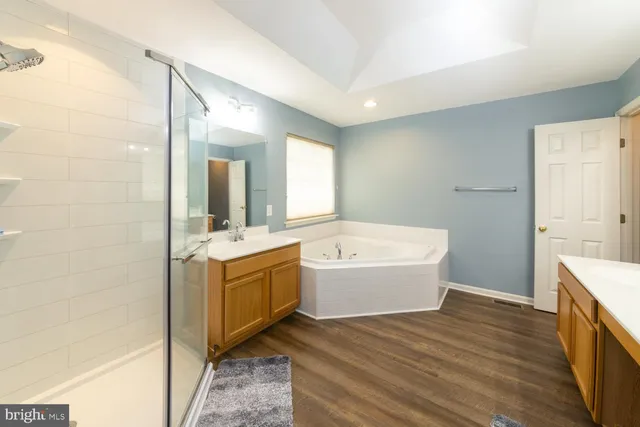 a bathroom with a tub sink and mirror
