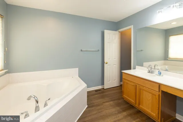 a bathroom with a tub sink and mirror