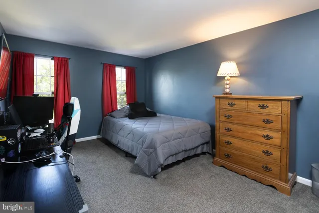 a bedroom with a bed and a flat tv screen on the dresser