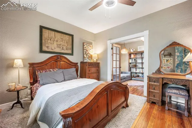 a bedroom with a bed a bookshelf and painting on the wall