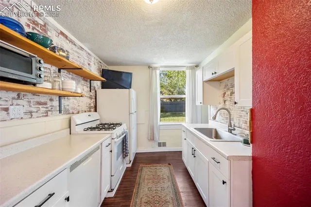 a kitchen with stainless steel appliances granite countertop a sink and a stove