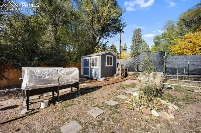 a view of a roof deck with couches and wooden fence