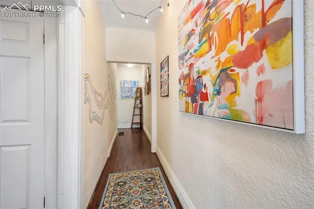 a view of a hallway with wooden floor and stairs