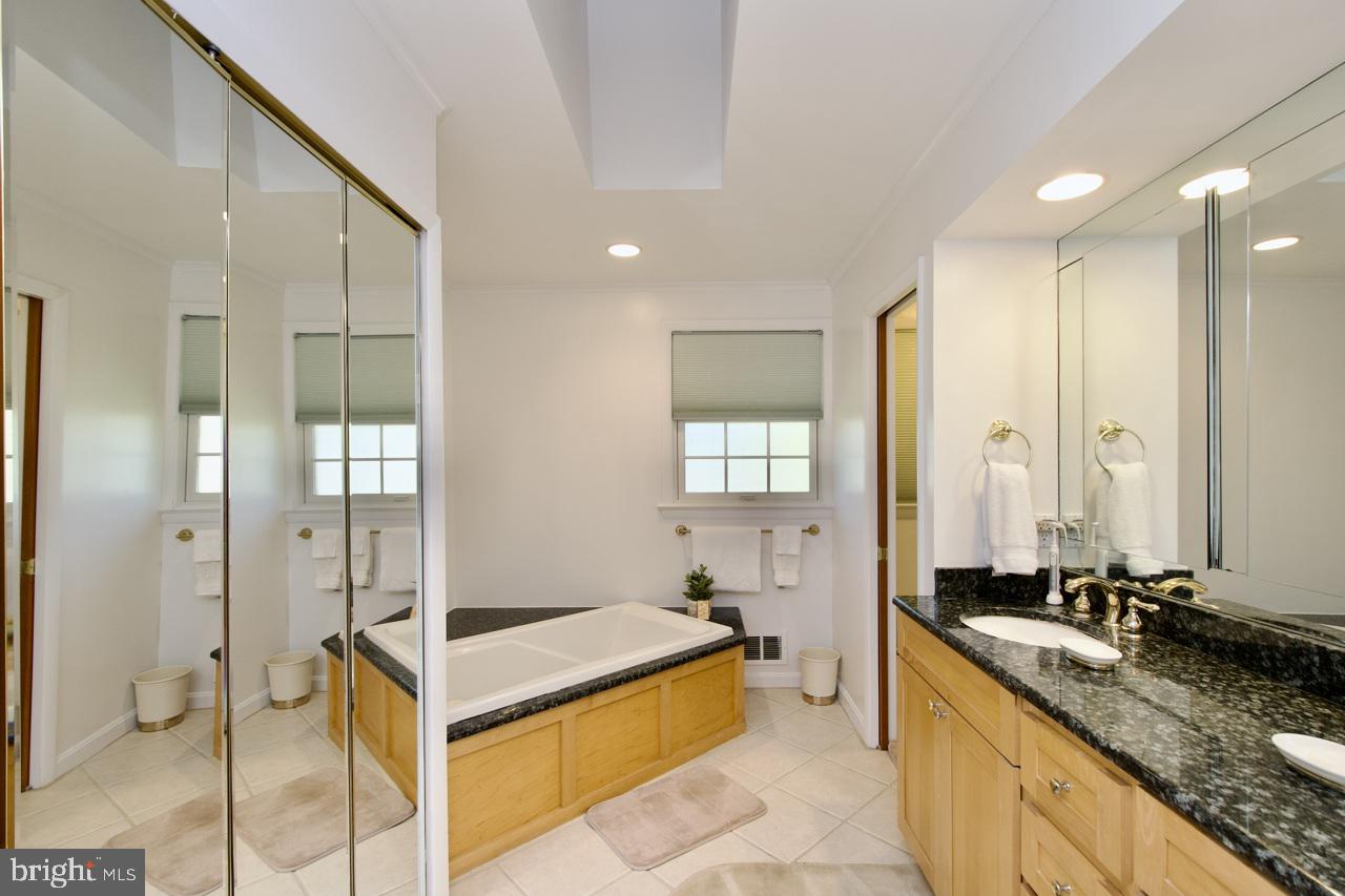 6613 Kerns Road Falls Church, VA 22042 - Photo 18 of 48 a spacious bathroom with a granite countertop tub sink and mirror