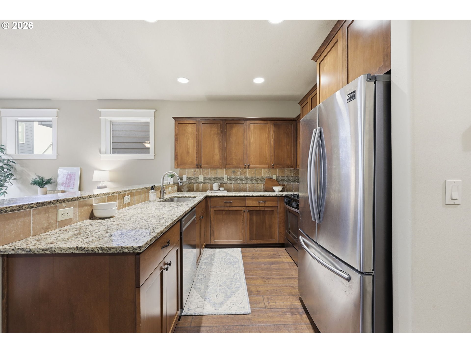 11033 Southwest Legacy Oak Way Portland, OR 97223 - Photo 12 of 47 a kitchen with granite countertop a refrigerator and a sink
