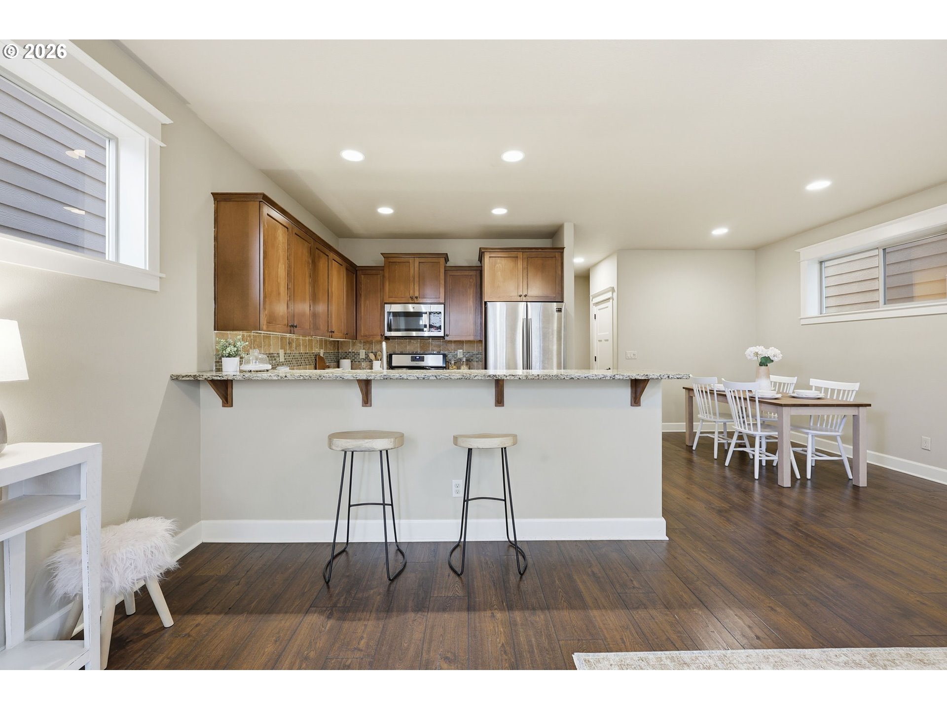 11033 Southwest Legacy Oak Way Portland, OR 97223 - Photo 10 of 47 a open kitchen with stainless steel appliances granite countertop a dining table chairs and granite counter tops