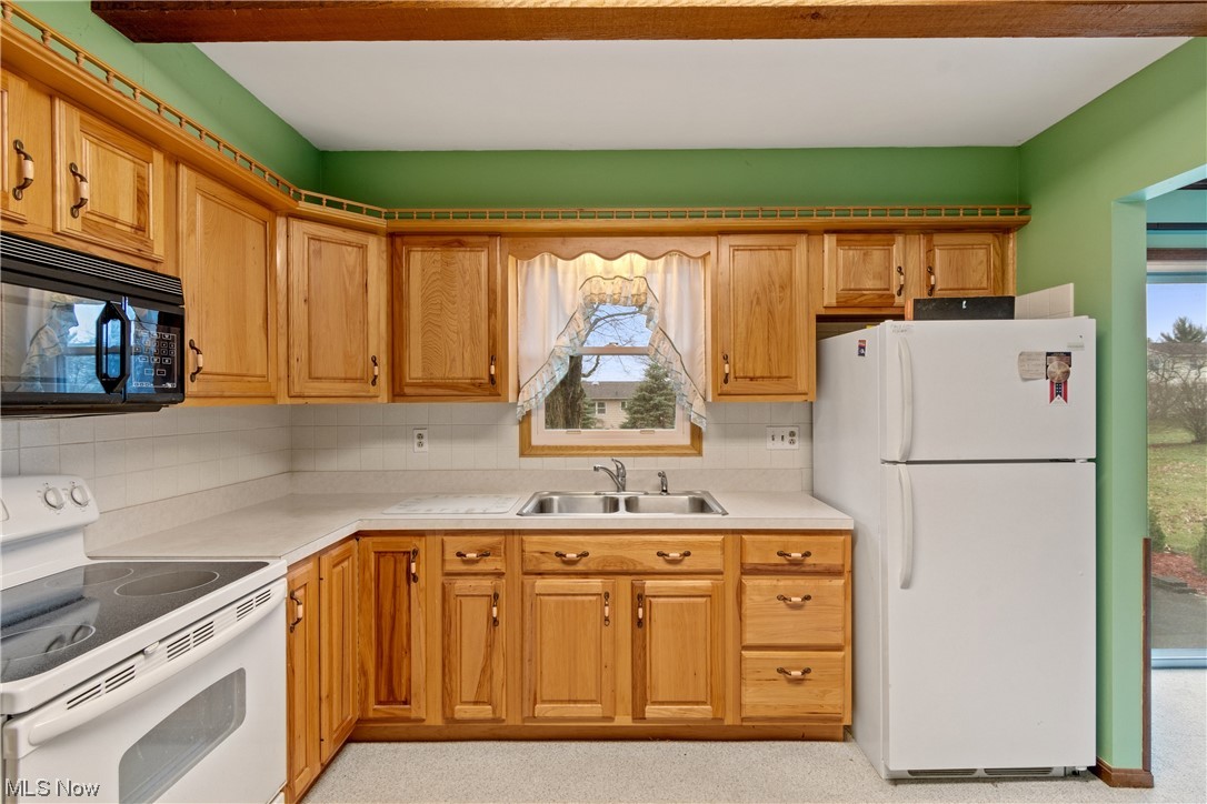41 Willard Street Rittman, OH 44270 - Photo 9 of 25 Kitchen featuring backsplash, white appliances, sink, and plenty of natural light