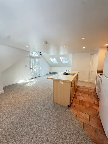 a view of kitchen with stainless steel appliances granite countertop refrigerator sink and stove
