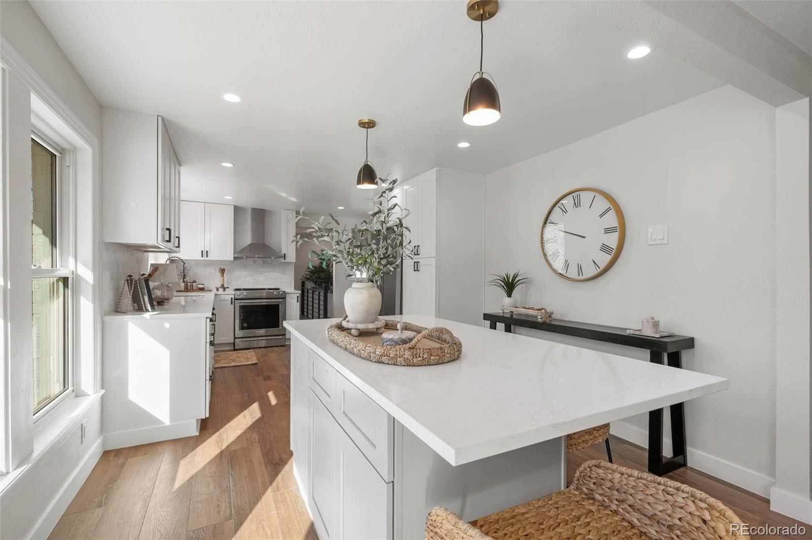 4481 Carr Street Wheat Ridge, CO 80033 - Photo 13 of 30 a living room with stainless steel appliances kitchen island granite countertop furniture a rug kitchen view and a chandelier