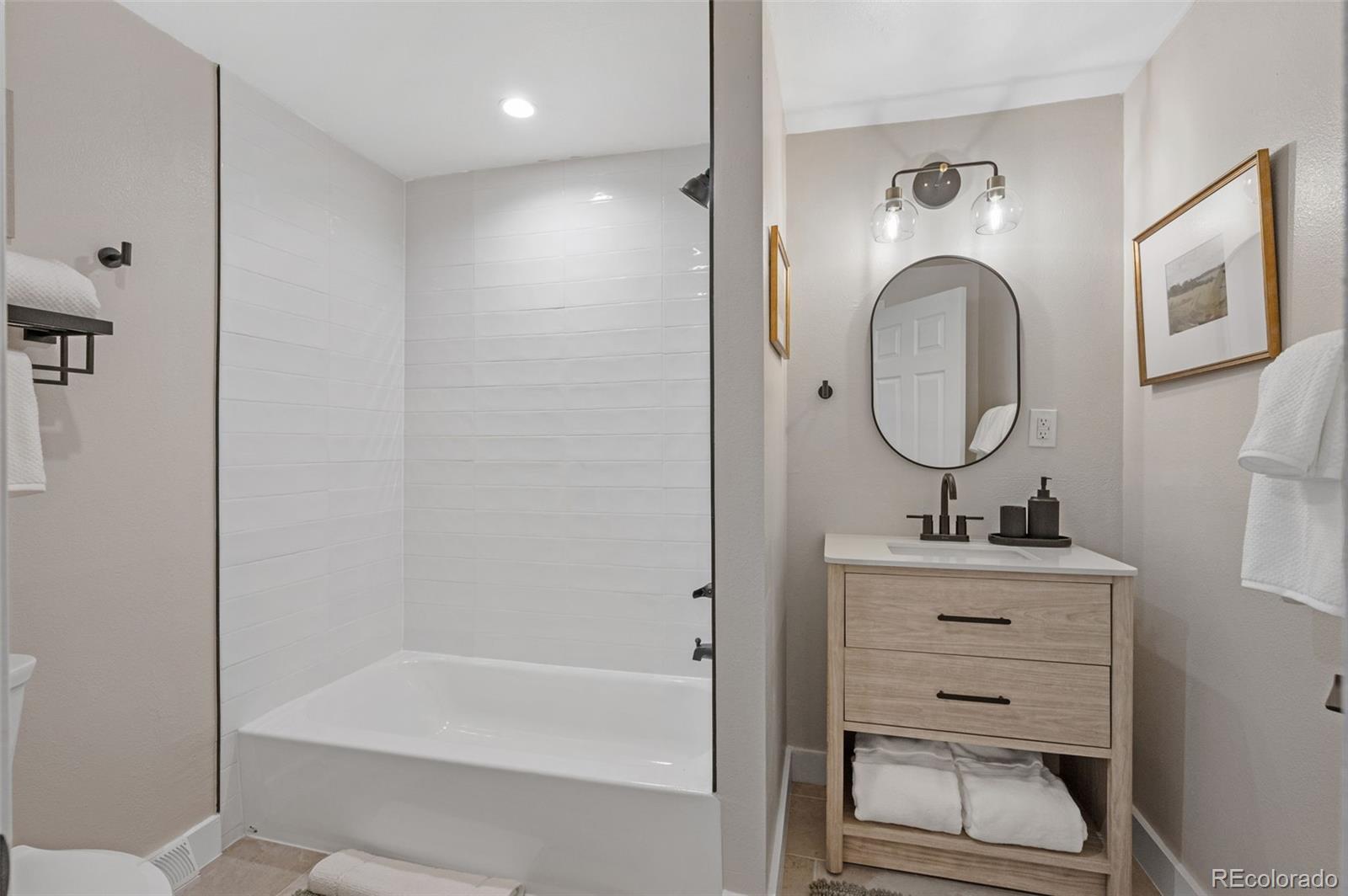 4481 Carr Street Wheat Ridge, CO 80033 - Photo 23 of 30 a bathroom with a sink a toilet and a mirror