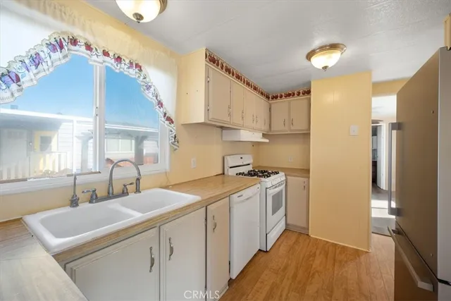 a kitchen with granite countertop a sink a stove and cabinets