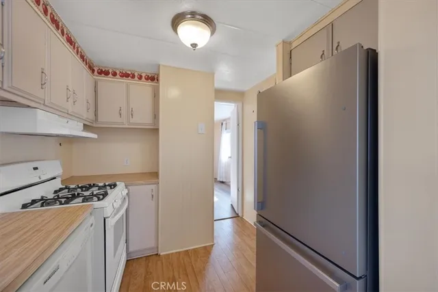 a kitchen with a sink dishwasher a refrigerator and cabinets