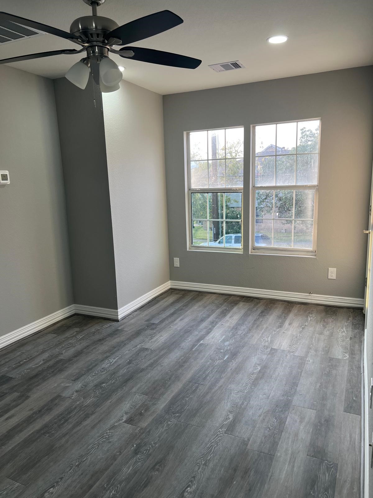 4011 Delano Street, Unit 4 Houston, TX 77004 - Photo 10 of 12 an empty room with wooden floor and windows