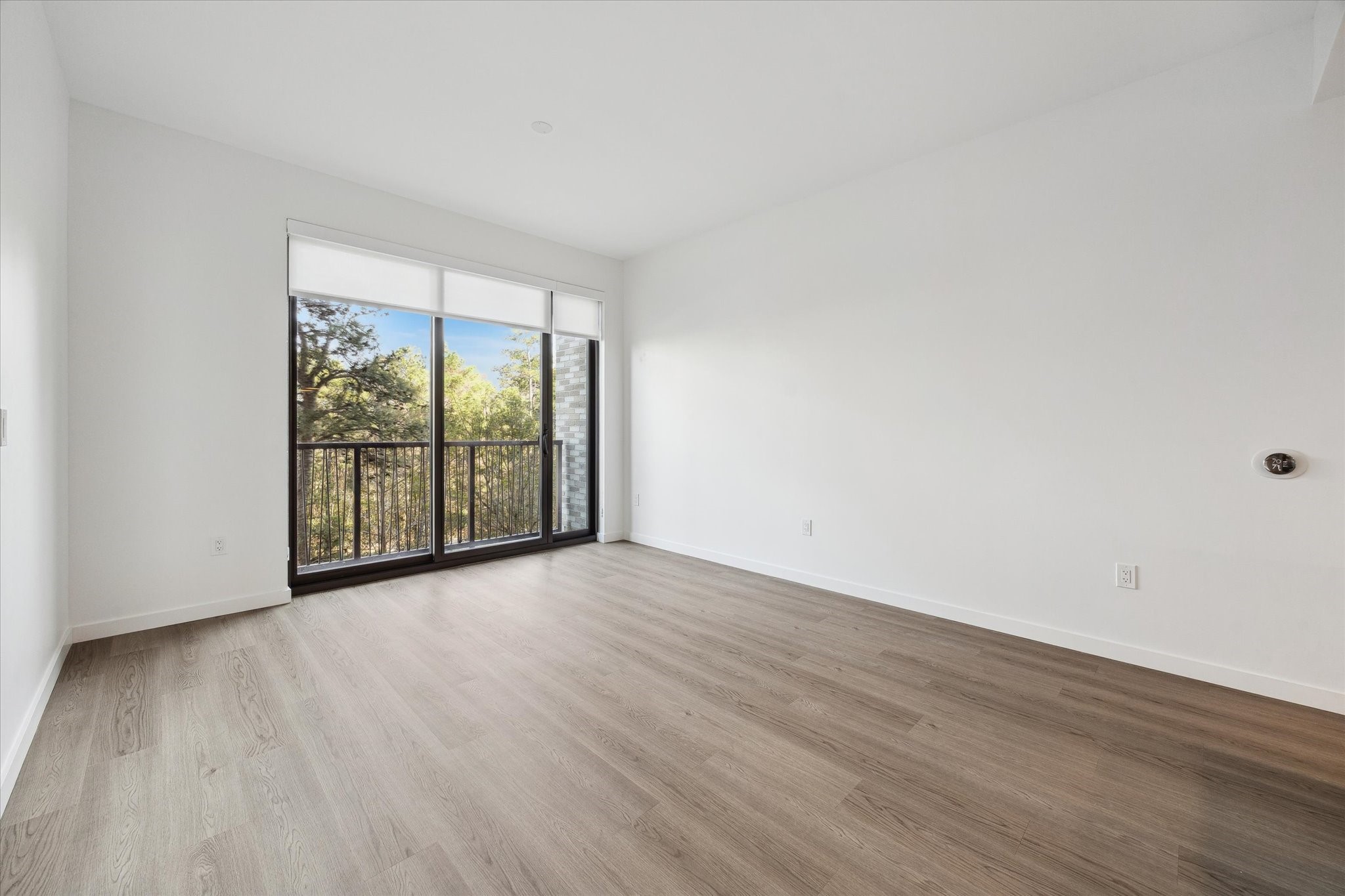1 Riva Row, Unit 406 The Woodlands, TX 77380 - Photo 5 of 42 wooden floor in an empty room with a window