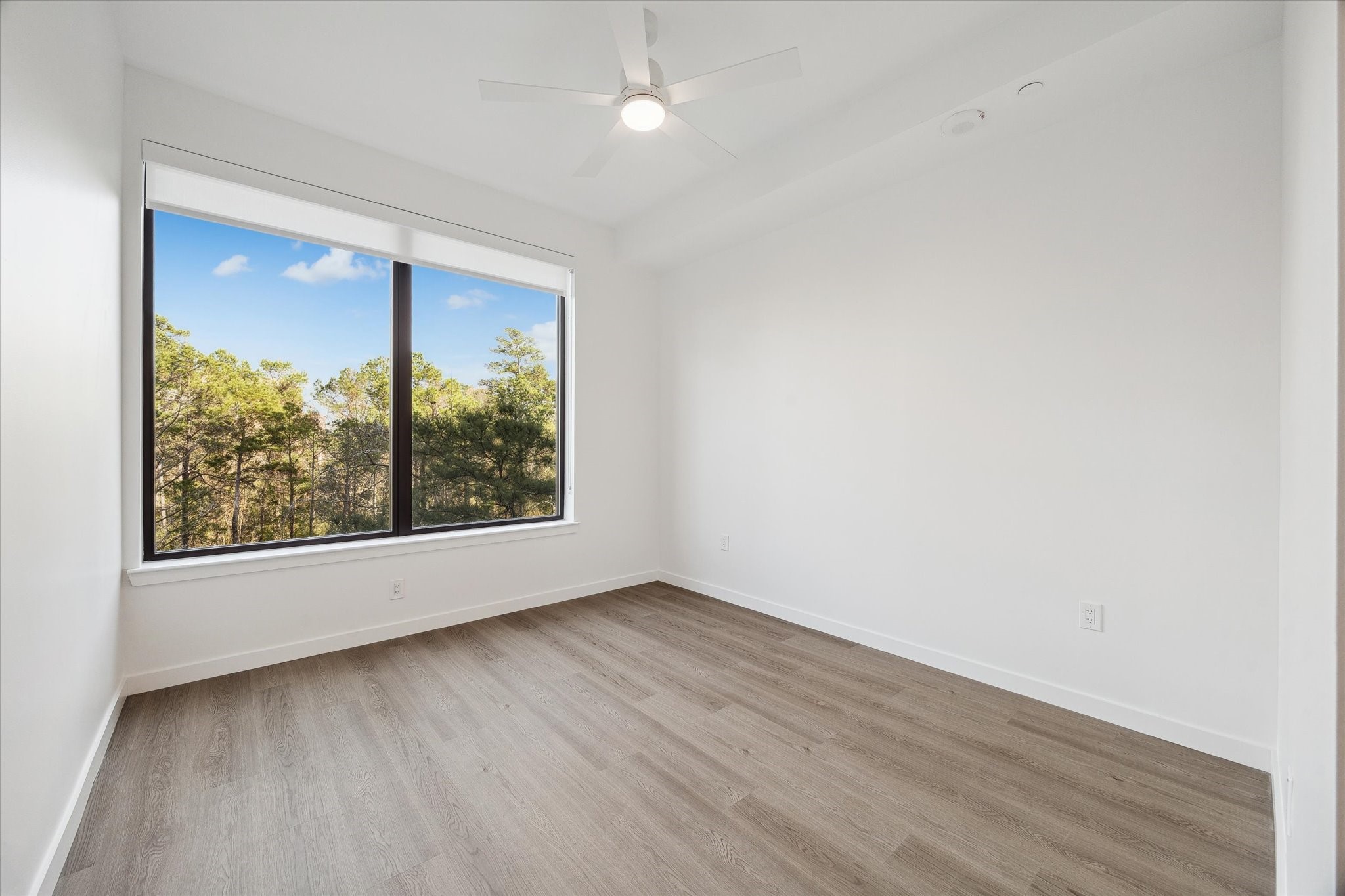 1 Riva Row, Unit 406 The Woodlands, TX 77380 - Photo 8 of 42 an empty room with wooden floor and windows