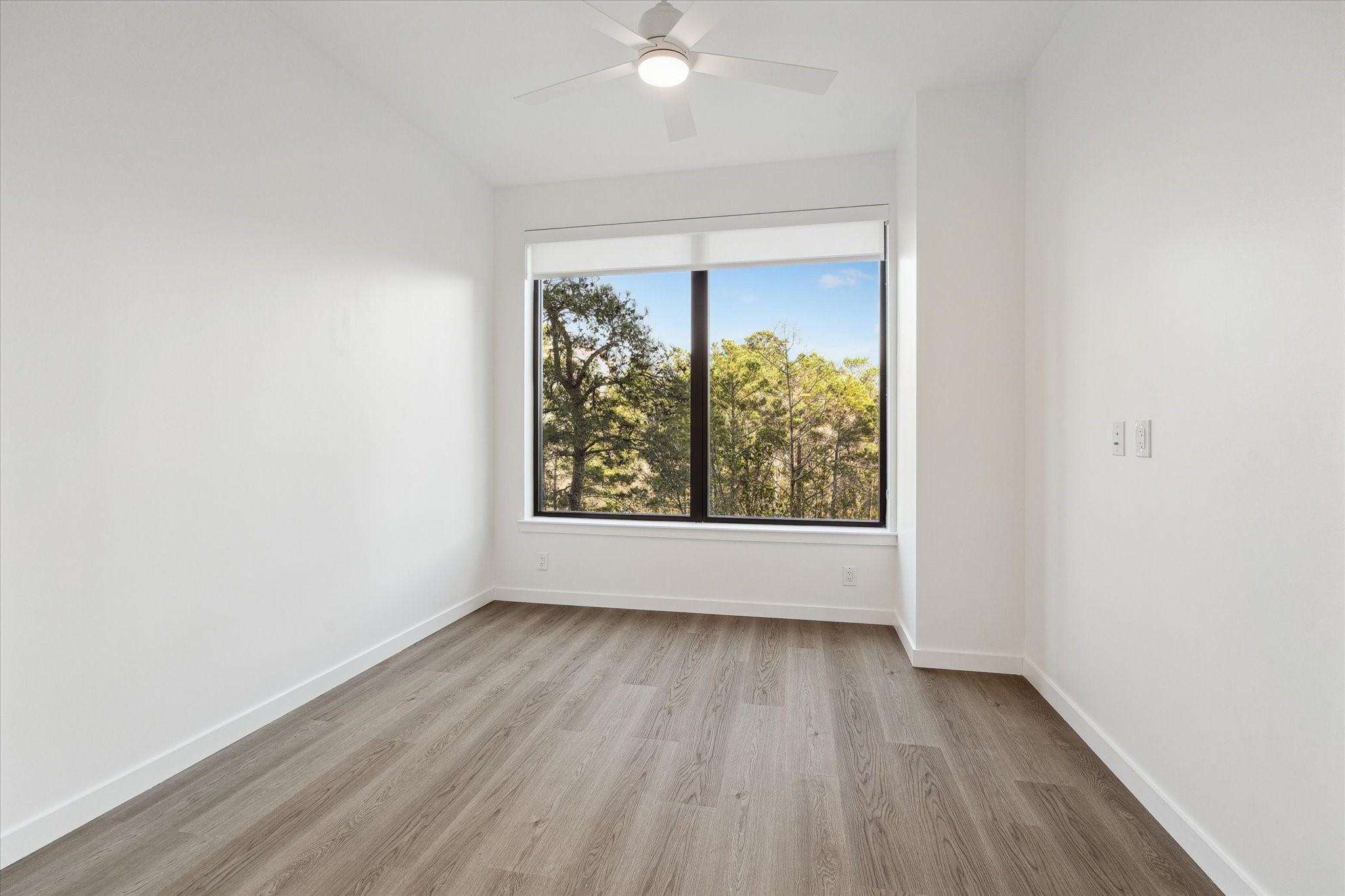 1 Riva Row, Unit 406 The Woodlands, TX 77380 - Photo 10 of 42 an empty room with wooden floor and windows