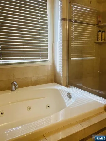 a bathroom with a bathtub and next to a window